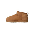 Vista lateral de la bota UGG Classic Ultra Mini en color chestnut mostrando la línea superior asimétrica, el pespunte central decorativo y la silueta de caña ultra corta.