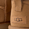 Detalle del talón con logotipo UGG en bota Classic Ultra Mini color Chestnut.