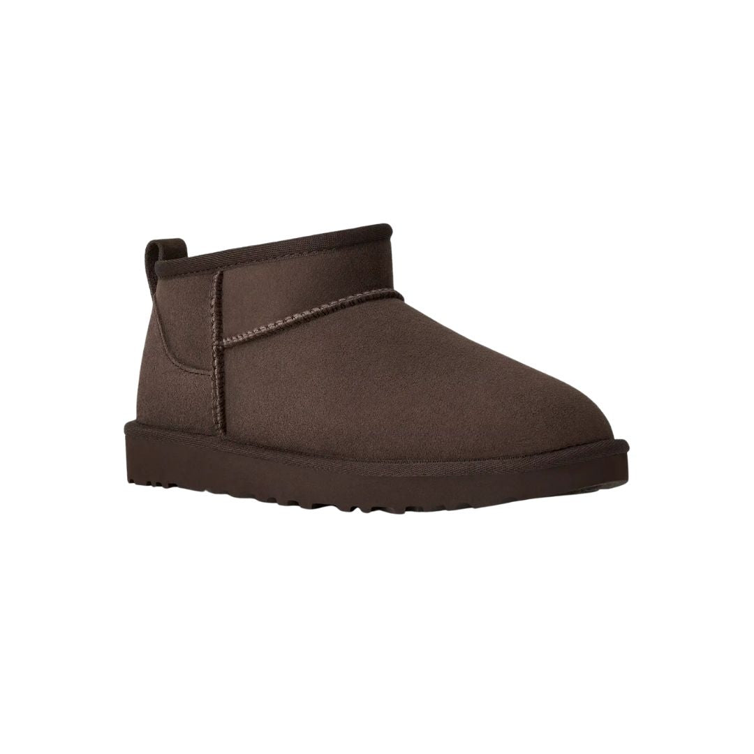 Vista en ángulo de tres cuartos de la bota UGG Classic Ultra Mini en color dusted cocoa destacando la puntera redondeada y la suela EVA antideslizante.