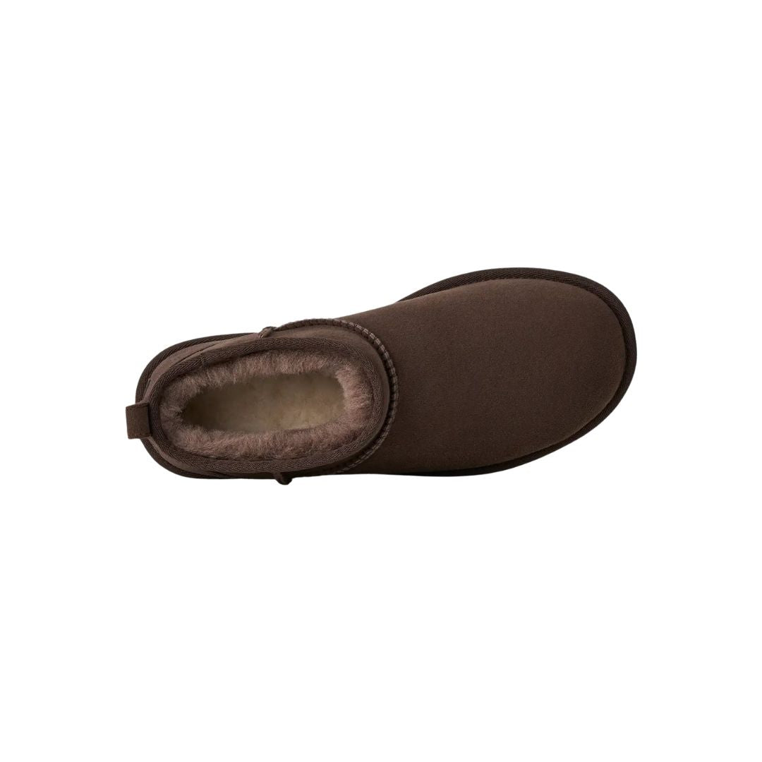 Vista cenital de la bota UGG Classic Ultra Mini en color dusted cocoa mostrando el interior forrado de piel de oveja en tono topo y la trabilla trasera para calzarla.