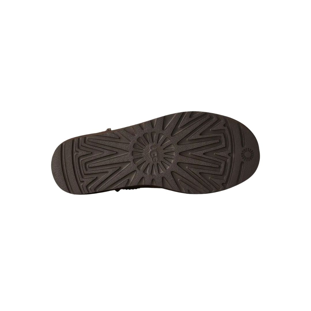 Suela de la bota UGG Classic Ultra Mini en color dusted cocoa mostrando el dibujo direccional de la banda de rodadura y el logotipo UGG grabado en el talón.