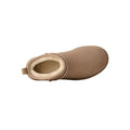 Vista cenital de la bota UGG Classic Ultra Mini en color sand mostrando el interior forrado de piel de oveja en tono crudo y la trabilla trasera para calzarla fácil.