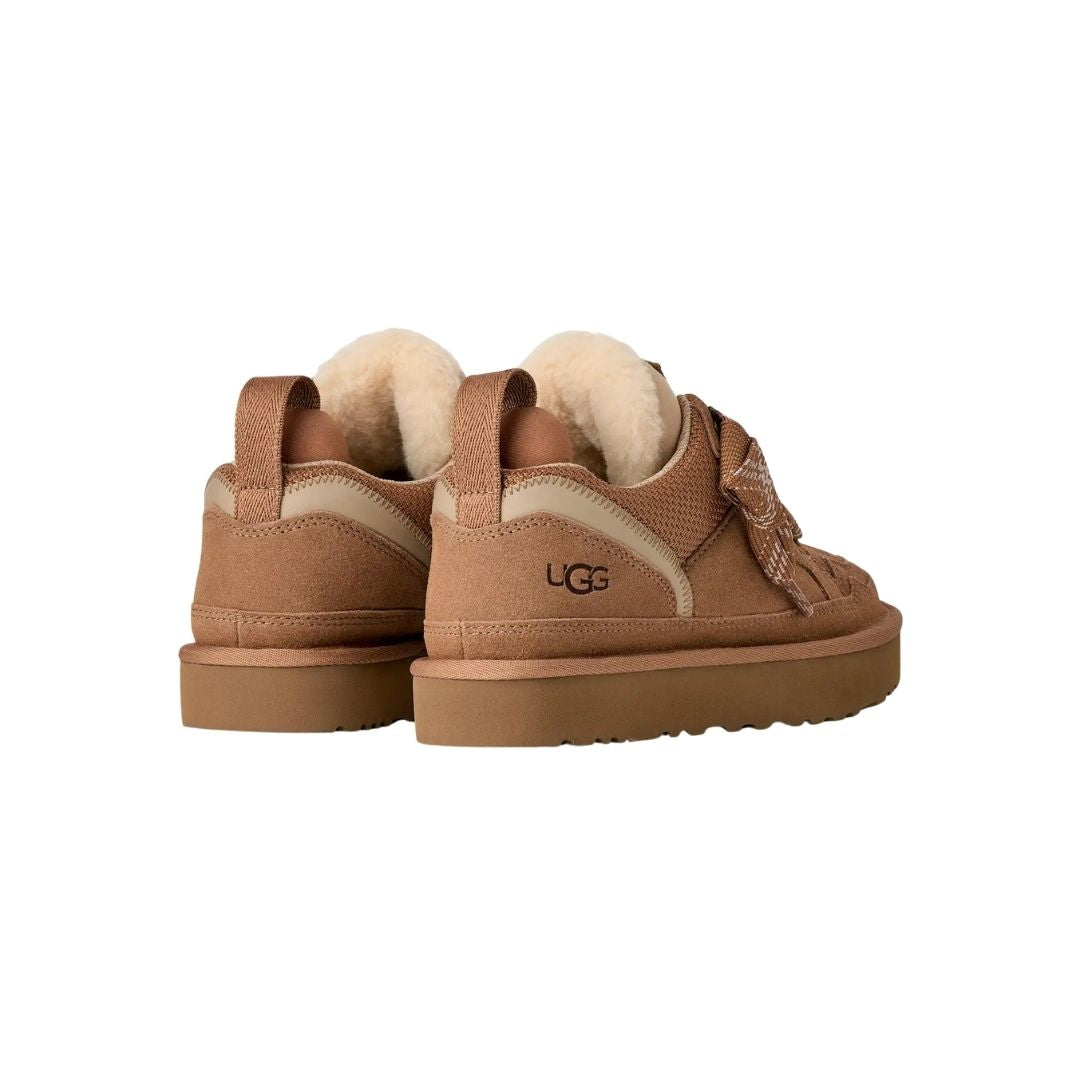 Par de zapatillas UGG Lowmel en color chestnut vistas desde atrás en ángulo, mostrando la correa de cincha en el talón y el forro de piel visible en el cuello.