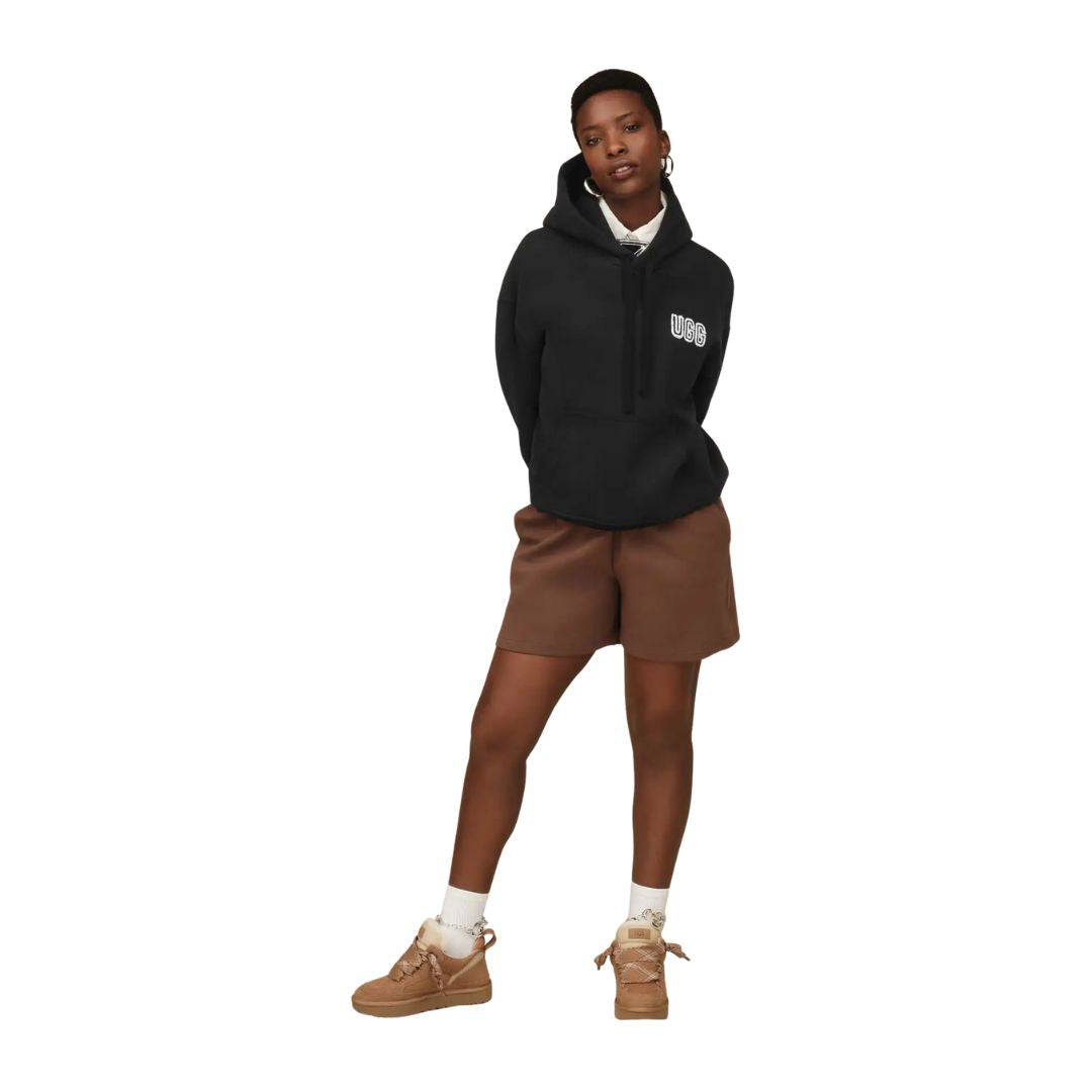 Modelo luciendo las zapatillas UGG Lowmel color chestnut combinadas con look casual urbano.