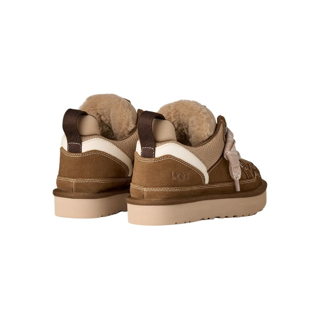 Par de zapatillas UGG Lowmel en color light bronze vistas desde atrás en ángulo, mostrando el forro de piel visible en el cuello y la correa de tirador.