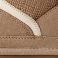 Primer plano del empeine de la zapatilla UGG Lowmel en color sand mostrando la combinación de ante, malla de lona balística y las costuras sobrehiladas.