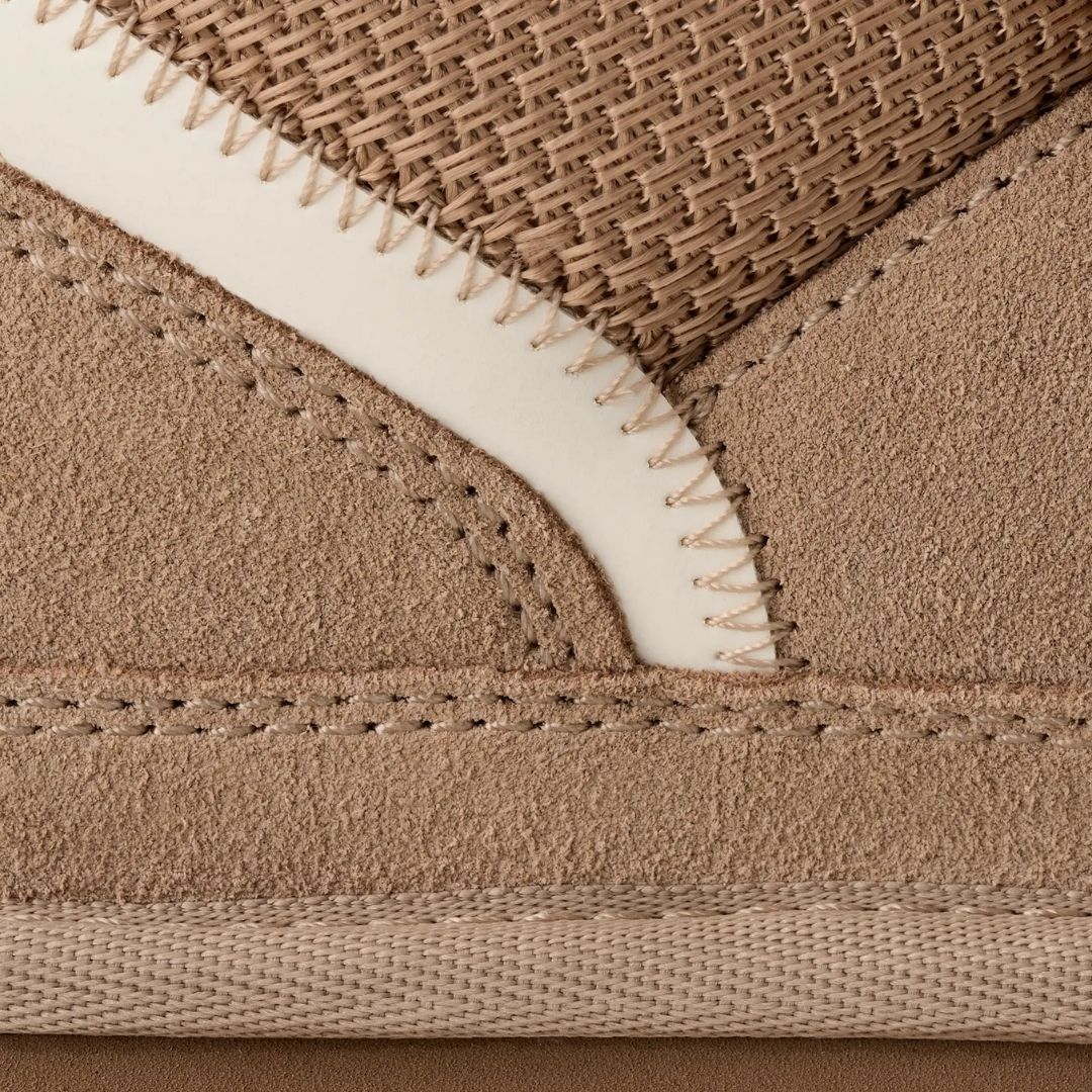 Primer plano del empeine de la zapatilla UGG Lowmel en color sand mostrando la combinación de ante, malla de lona balística y las costuras sobrehiladas.