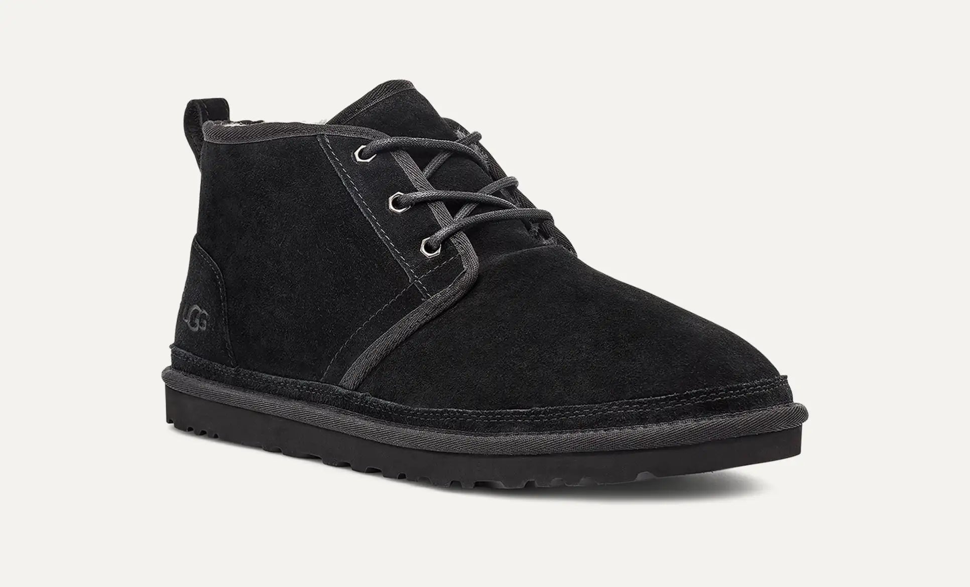 Bota UGG Neumel negra vista en ángulo tres cuartos mostrando su diseño chukka de ante.