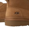 Detalle del talón de la bota UGG Neumel Moc color castaño con logotipo grabado en ante.
