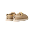 Vista trasera de las UGG Tasman Biarritz color mustard seed con tirador de ante y detalles decorativos.