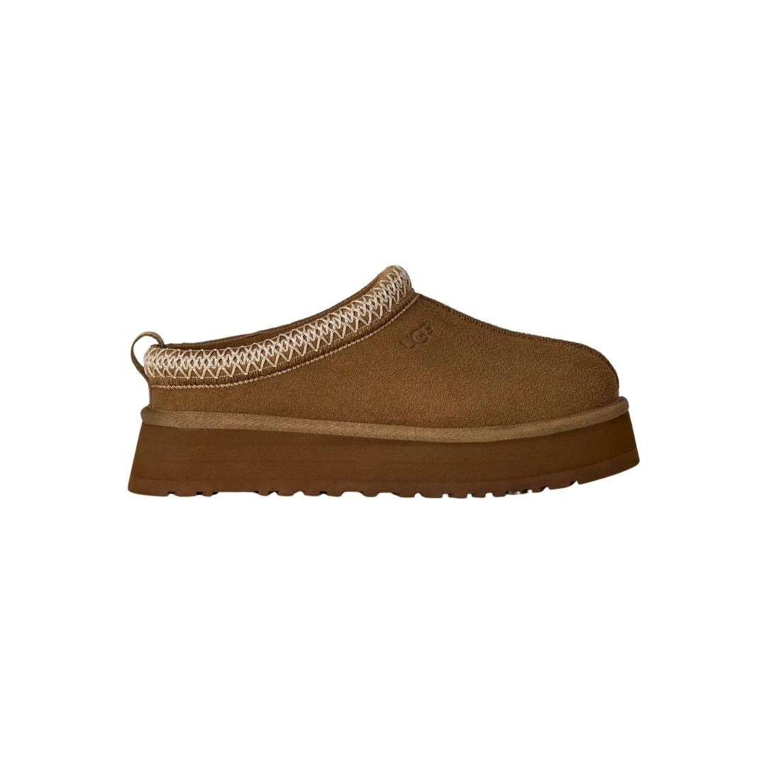 Zueco UGG Tazz II en color light bronze de perfil completo sobre fondo blanco, mostrando su silueta tipo mule y la plataforma acanalada característica.