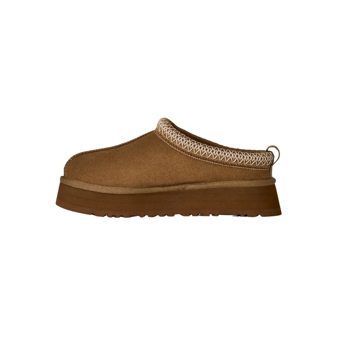 Vista lateral del zueco UGG Tazz II en color light bronze mostrando el empeine de ante liso, el ribete UGGbraid bordado y la suela de plataforma en EVA.