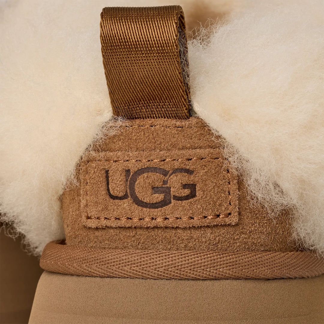 Detalle del talón de la UGG Tazzelle color chestnut con forro de piel de oveja y logotipo UGG grabado.