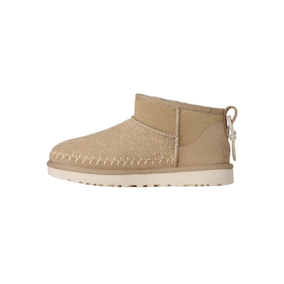 Vista lateral izquierda de las botas UGG Ultra Mini Biarritz color Mustard Seed mostrando costuras decorativas.