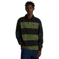 Primer plano frontal del polo de rugby Vans Ward de punto a rayas verde y negro, con cuello negro, tapeta de botones y logotipo Vans bordado en el pecho, sobre vaqueros azules.