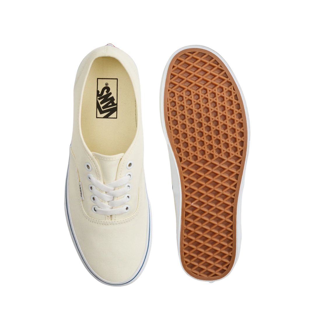 Vans Authentic White vista superior de zapatilla de lona blanca con cordones blancos y suela waffle marrón.