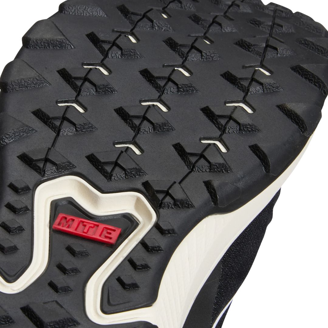 Primer plano de la suela de la zapatilla Vans MTE Crosspath en negro y blanco, con el dibujo de tacos de la suela All-Trac y la etiqueta roja MTE en la entresuela.