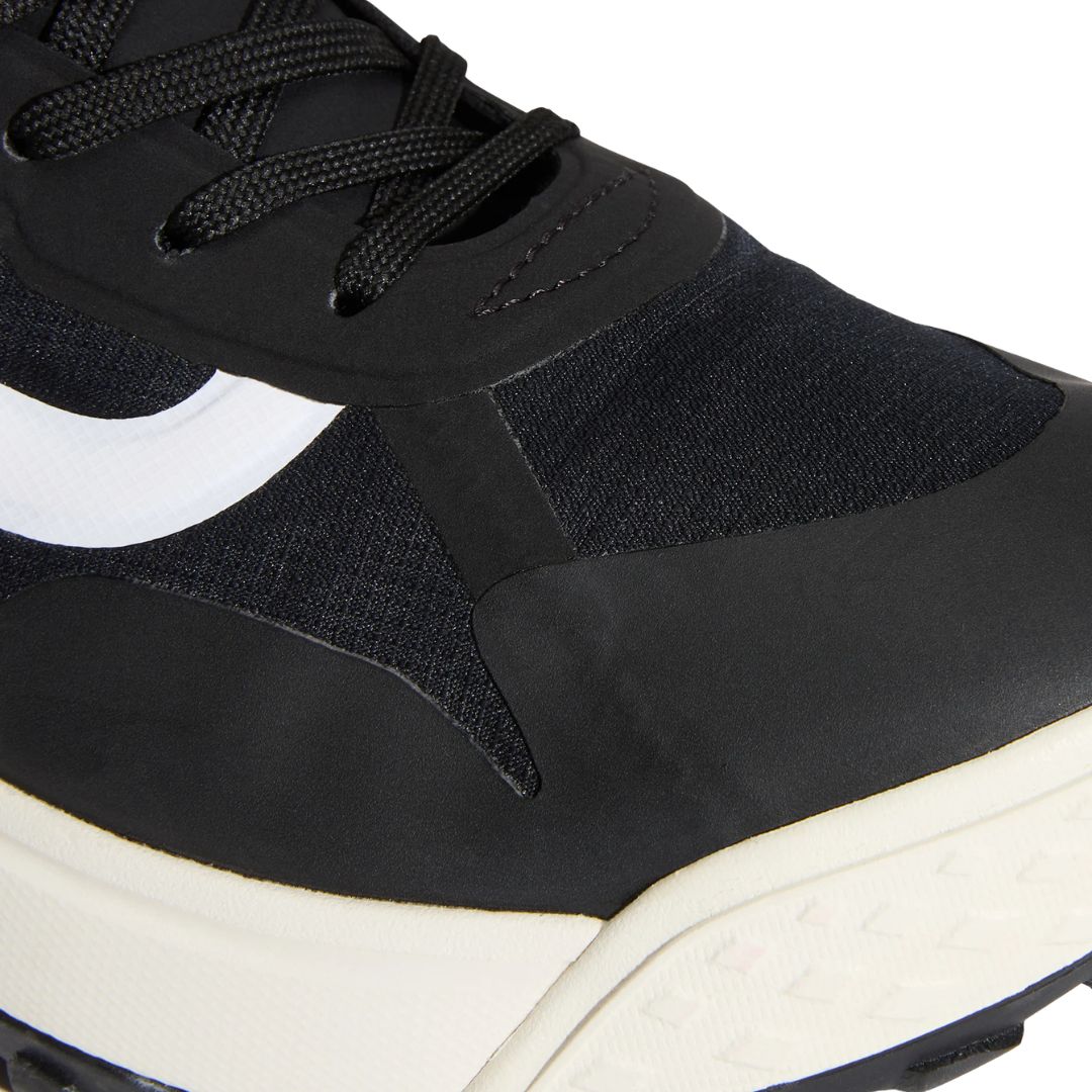 Primer plano frontal de la puntera de la zapatilla Vans MTE Crosspath en negro y blanco, mostrando los paneles de malla y sintético y el cierre de cordones.