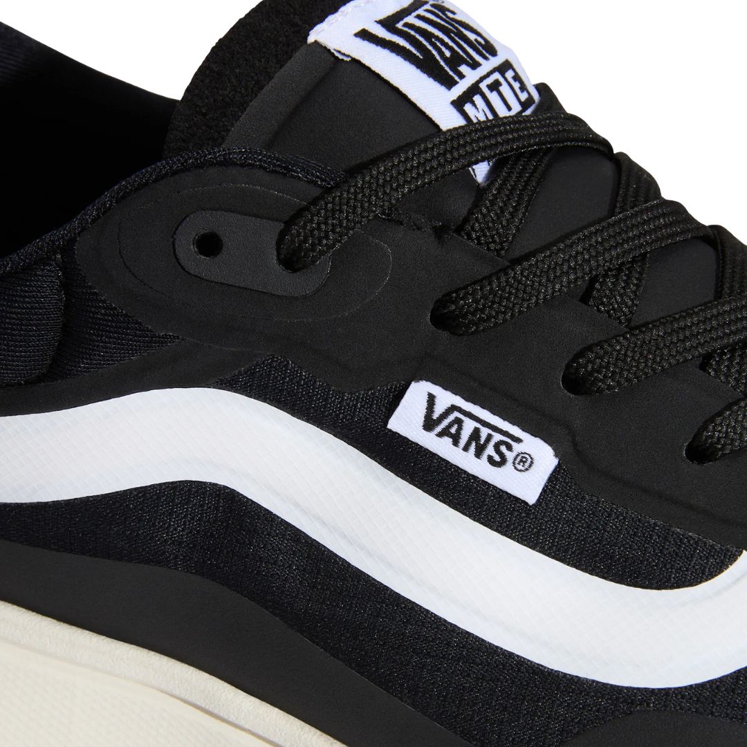 Primer plano superior de la zapatilla Vans MTE Crosspath en negro y blanco, mostrando los cordones, la lengüeta con etiqueta Vans MTE y la Sidestripe blanca.