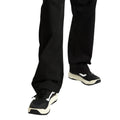 Detalle de las piernas de un hombre con pantalón ancho negro calzando las zapatillas Vans MTE Crosspath en negro y blanco, vista frontal de ambos pies caminando.