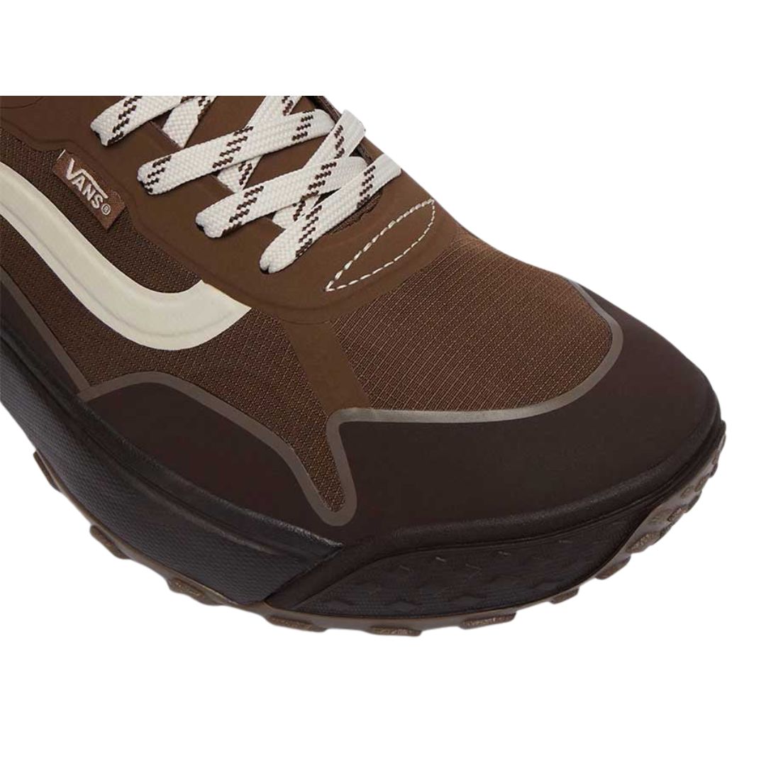 Zapatillas Vans Crosspath en vintage cocoa: primer plano de la puntera con malla marrón, franja lateral blanca, cordones planos bicolores y refuerzo de goma oscura en el contorno de la suela dentada.