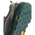 Primer plano de la suela de la zapatilla Vans Crosspath XC en verde salvia y oatmeal, con la etiqueta amarilla Vibram y el dibujo de tacos ranurado en verde oscuro.