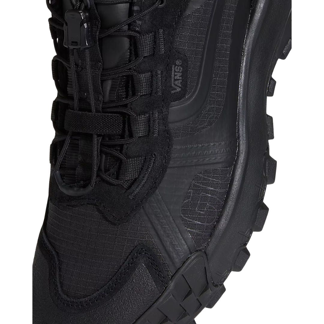 Primer plano de los cordones y el clip Speedlace de la zapatilla Vans Crosspath XC Gore-Tex en negro, con el logotipo Vans grabado en el lateral y la suela Vibram al fondo.