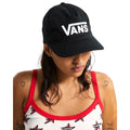 Modelo llevando gorra Vans Drop V Logo Snapback Hat negra con logo blanco bordado, ajuste clásico y diseño urbano estilo skate.