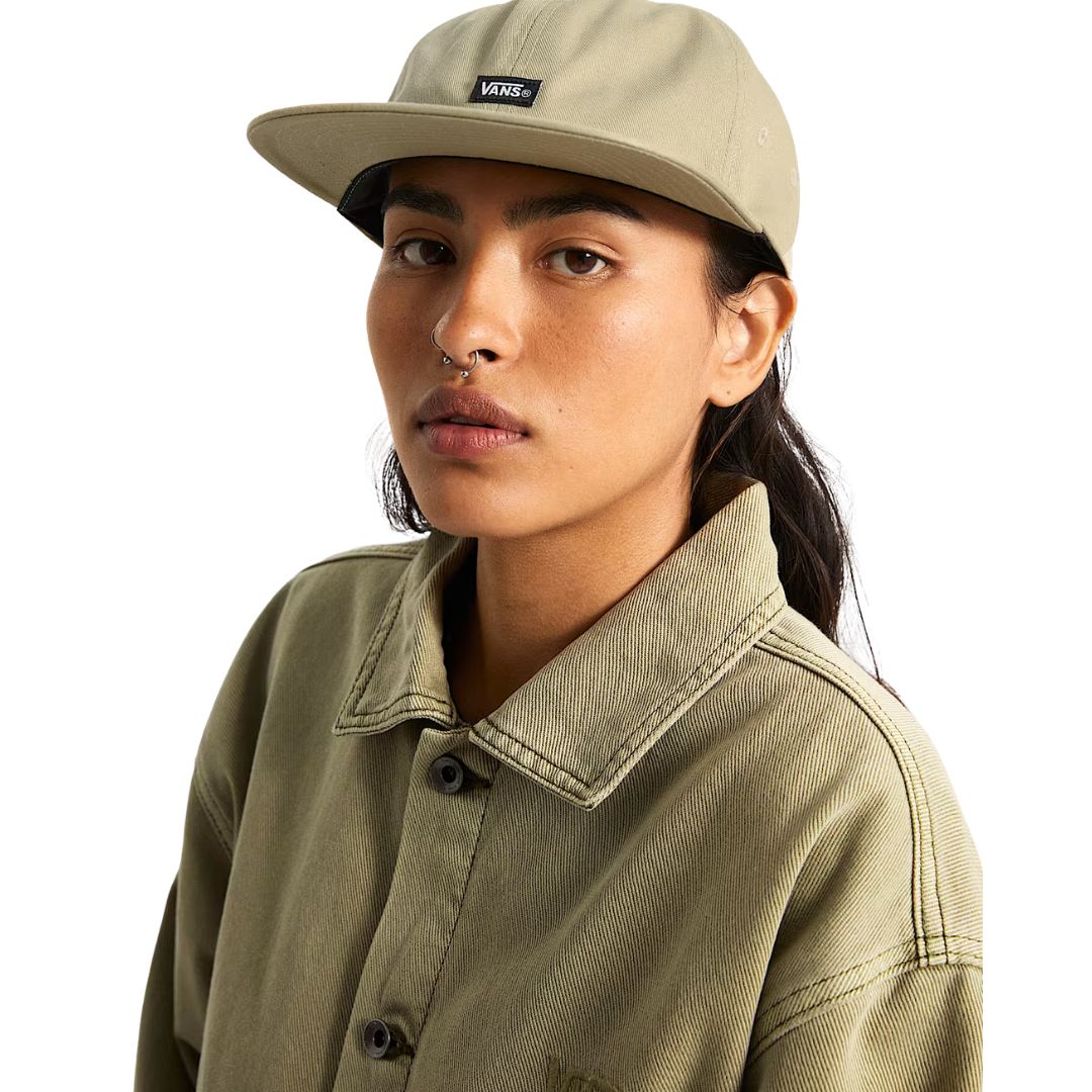 Modelo con Vans Jockey color Elm puesta, gorra clásica de seis paneles con visera plana y ajuste personalizado.