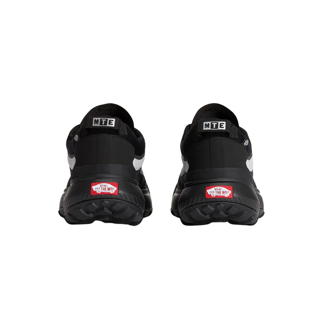 Parte trasera de las Vans MTE Crosspath negras reflectantes, con tiradores MTE y logo Vans en el talón.