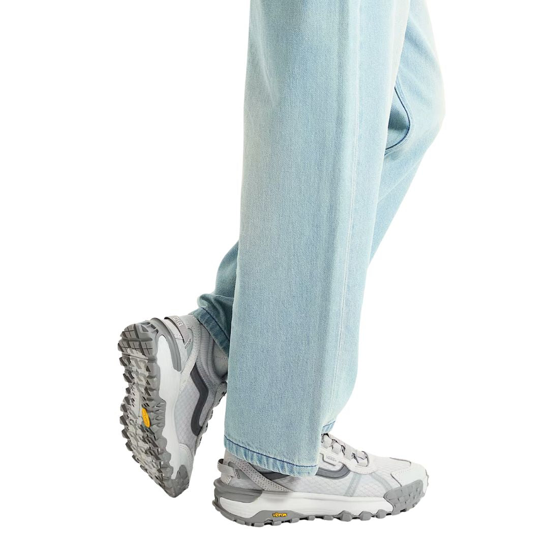 Zapatillas Vans MTE Crosspath XC en color gris claro, combinadas con pantalón vaquero para uso urbano.