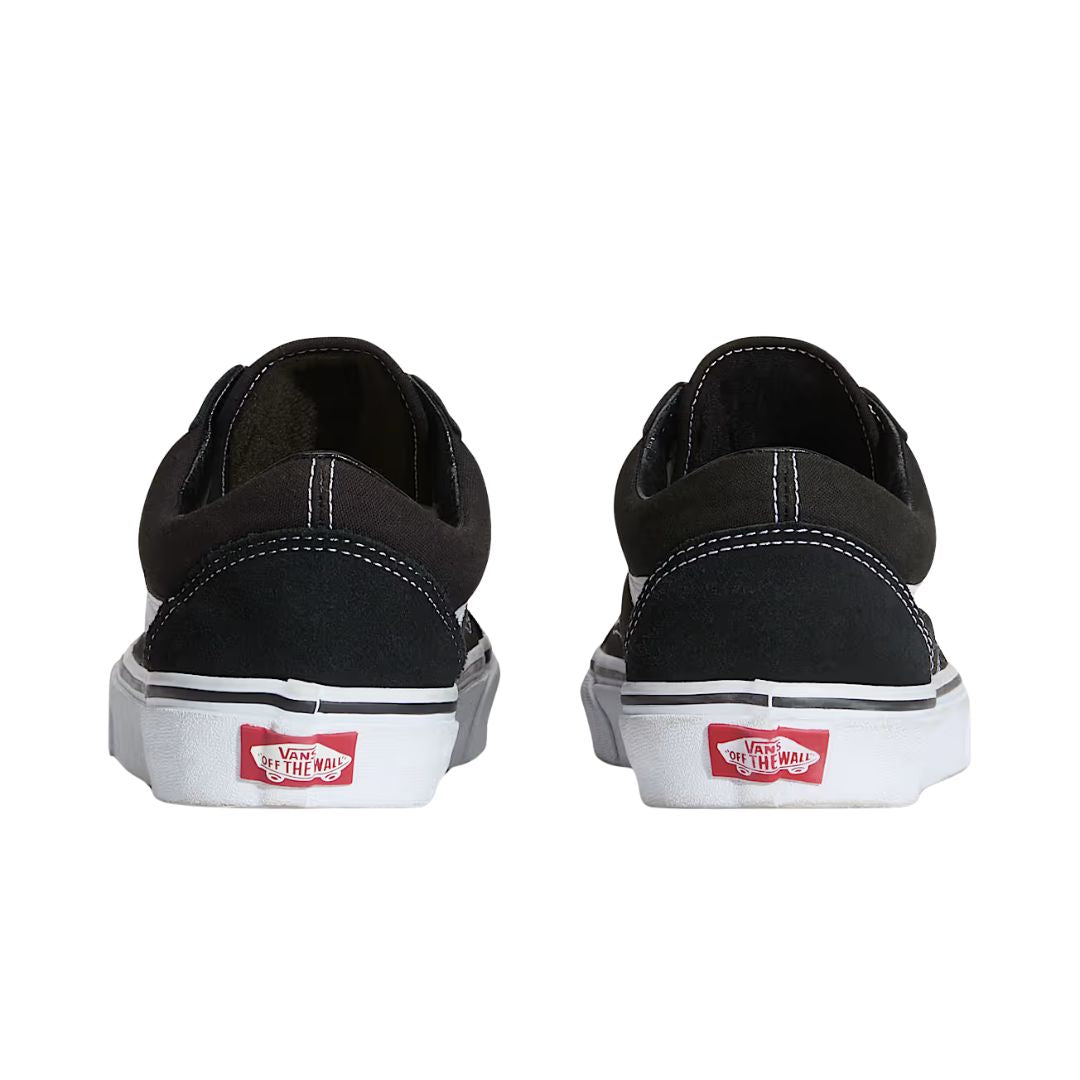 Vans Old Skool Black White vista lateral interior con Sidestripe blanca, upper negro y suela blanca vulcanizada.