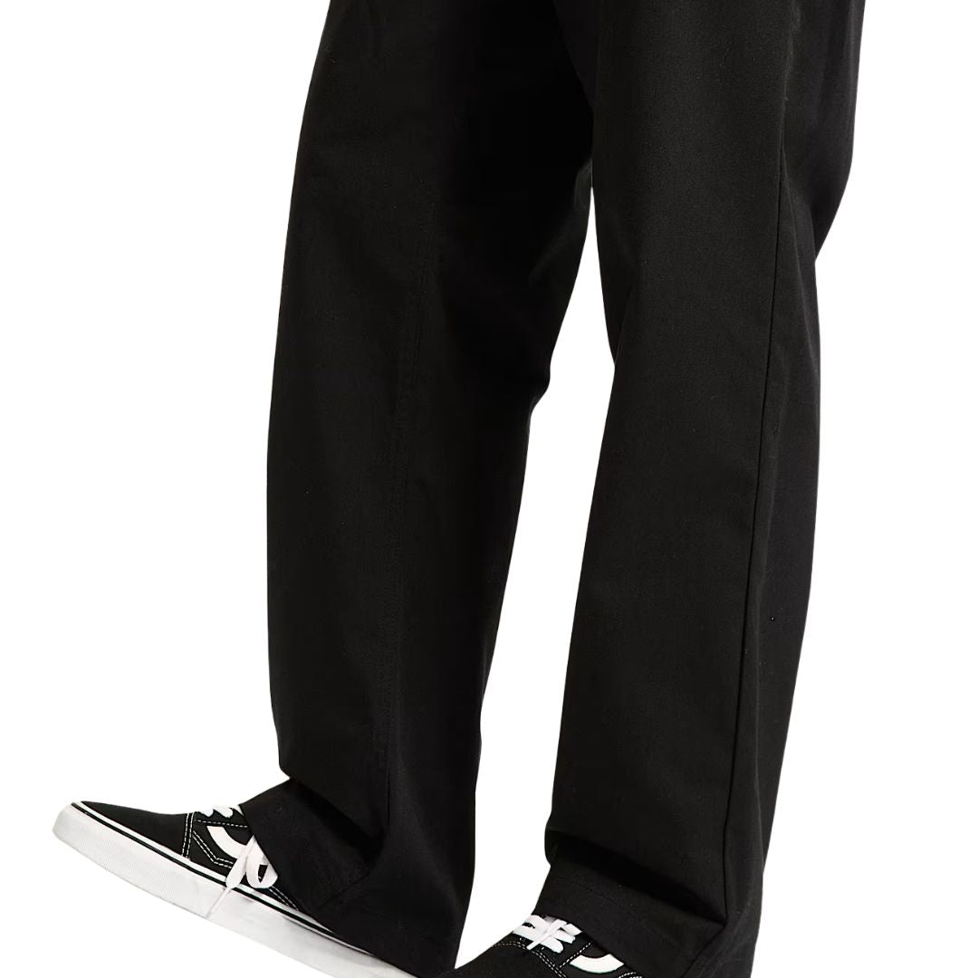 Zapatillas Vans Old Skool Black White puestas con pantalón negro, cordones blancos y suela blanca estilo skate clásico.