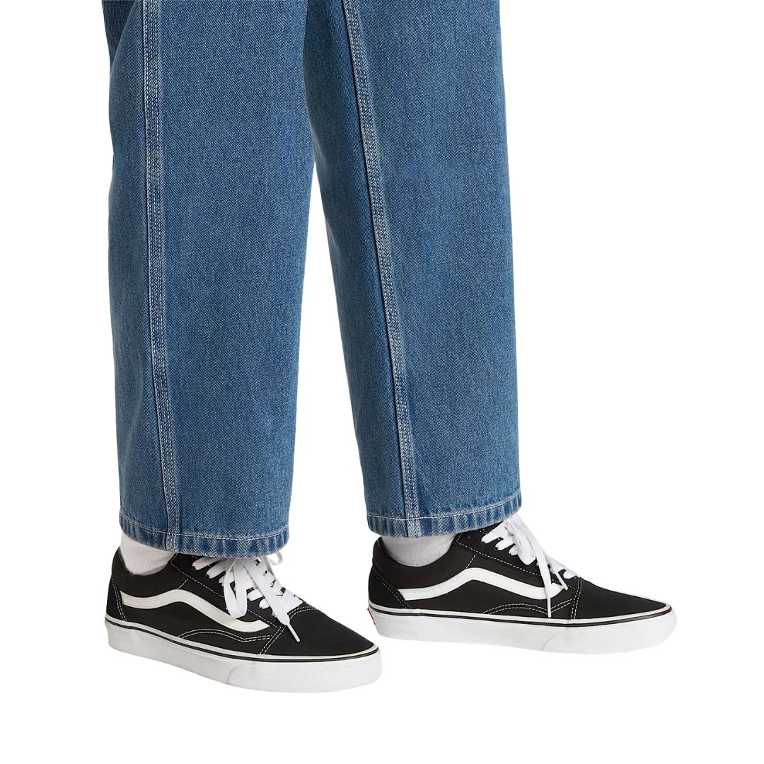 Zapatillas Vans Old Skool Black White vista lateral perfil completo con upper negro, Sidestripe blanca y suela waffle color caramelo.