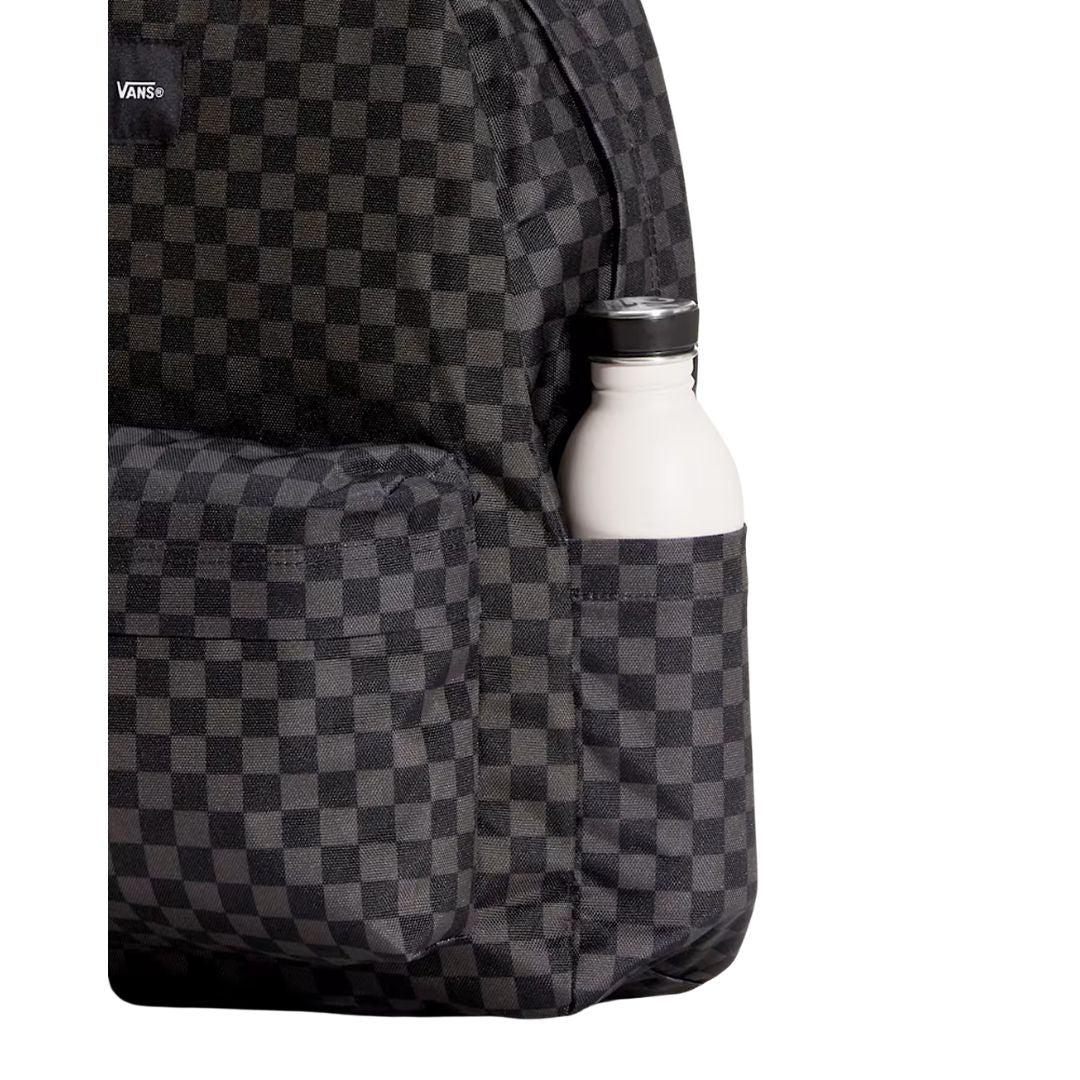 Mochila Vans Old Skool Check en negro y gris, detalle del bolsillo lateral con una botella de agua, mostrando la textura del estampado checkerboard de cerca.