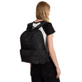 Mochila Vans Old Skool Check en negro y gris, foto de modelo llevándola a la espalda, mostrando el ajuste de las correas y el bolsillo lateral en uso real.