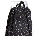 Mochila Vans Old Skool Classic en color black floral, detalle del asa superior junto a un portátil, mostrando la resistencia del agarre para transportarla.