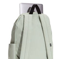 Mochila Vans Old Skool Classic en color dusty green, detalle del asa superior junto a un portátil, mostrando la resistencia del agarre para transportarla.