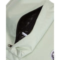 Mochila Vans Old Skool Classic en color dusty green, detalle del bolsillo frontal abierto con unos auriculares, mostrando la cremallera y el parche VANS.