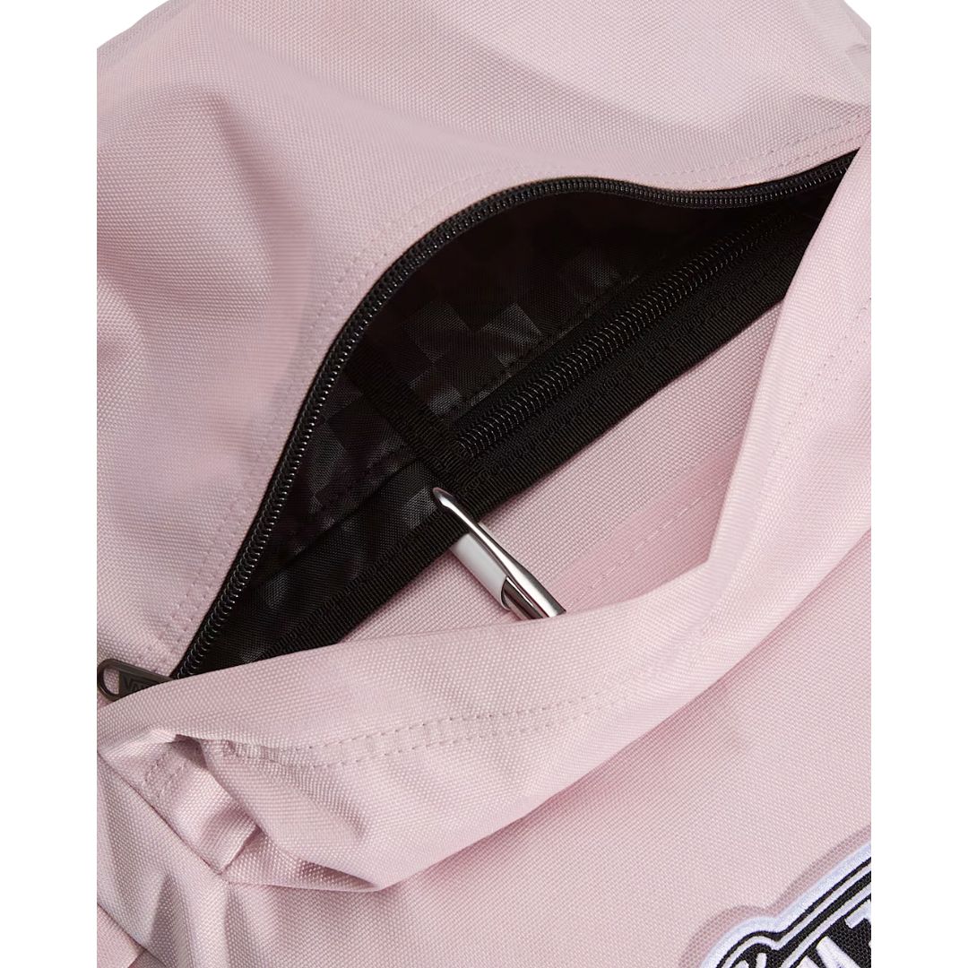 Mochila Vans Old Skool Classic en color pale pink, detalle del bolsillo frontal abierto con un bolígrafo, mostrando la cremallera y el parche VANS Off The Wall.