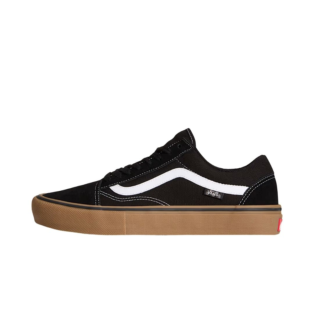 Vans Skate Old Skool en negro, vista de perfil mostrando la construcción en ante y lona, la franja lateral blanca y la voluminosa suela de goma gum tipo skate.