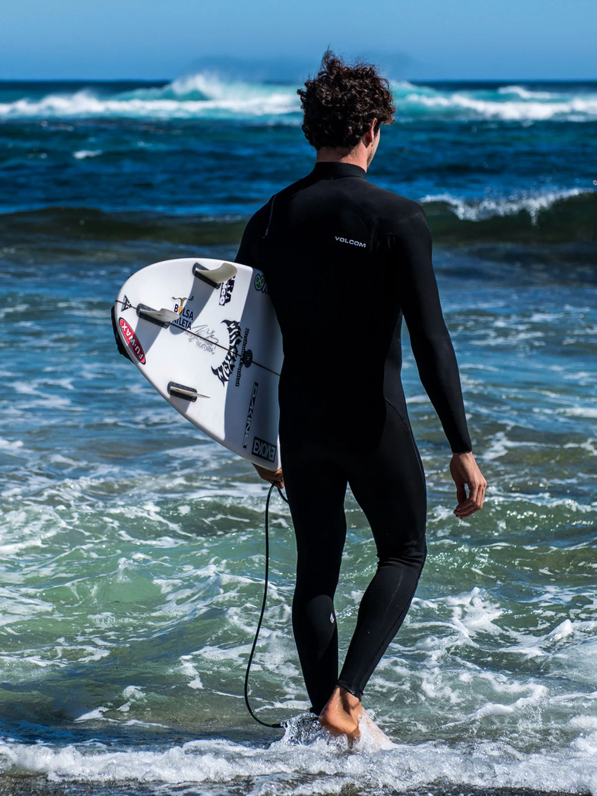 Hombre entrando en el agua con el Traje de neopreno con cremallera en el pecho Volcom 4/3mm Chest Zip Fullsuit