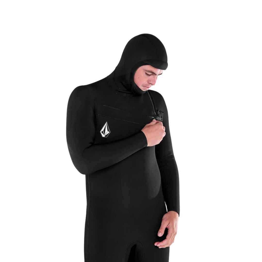 Modelo ajustando la cremallera frontal del traje de neopreno Volcom Modulator 5/4/3 mm negro con capucha.