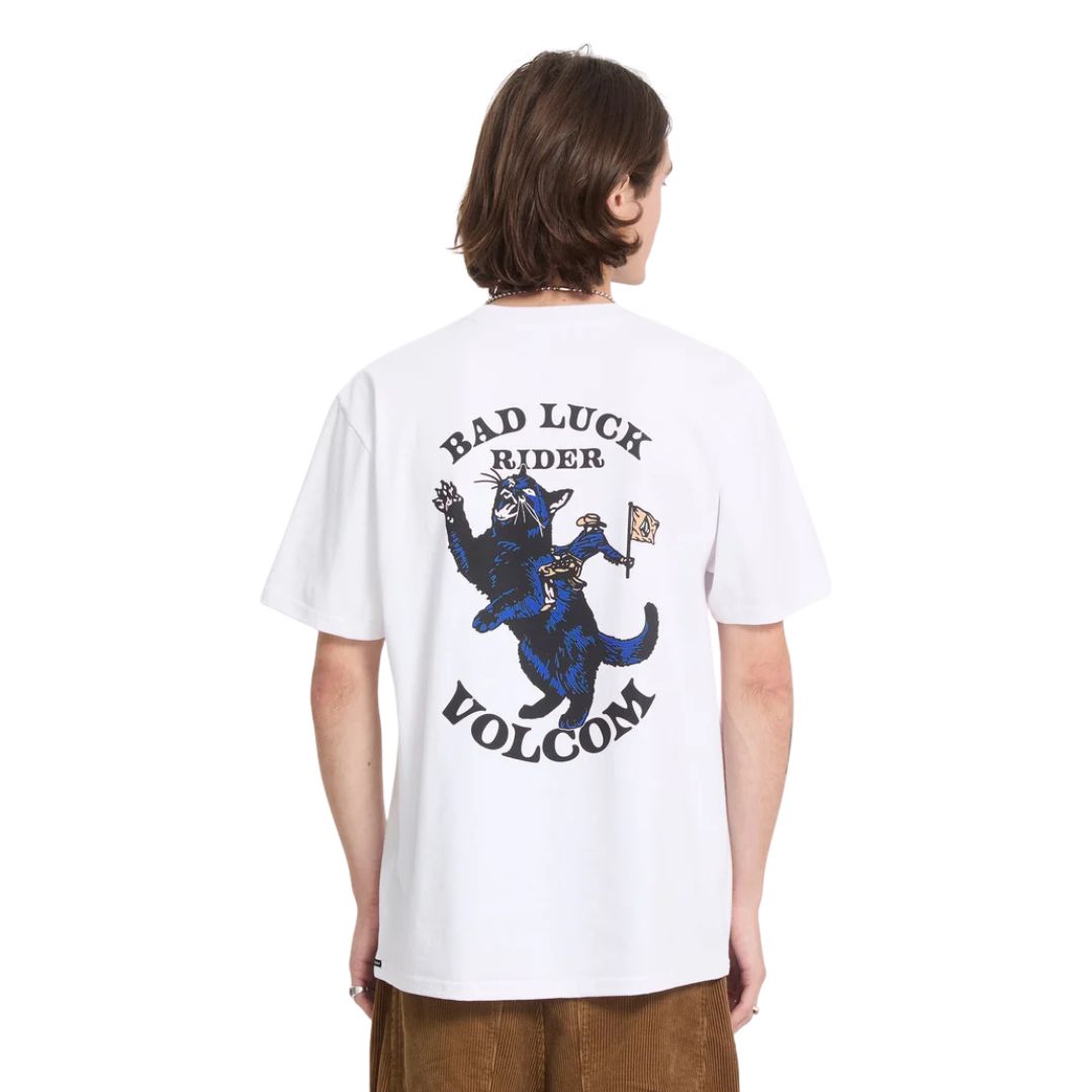 Modelo con la camiseta Volcom Bad Luck SST en color blanco de cuerpo entero, vista frontal con las manos en los bolsillos, mostrando el corte y la caída general de la prenda.