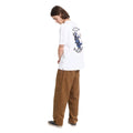 Camiseta Volcom Bad Luck SST en color blanco, vista de perfil con la mano cerca de la cintura, mostrando el pequeño escudo Volcom EST. 91 en el pecho y la caída de la manga.
