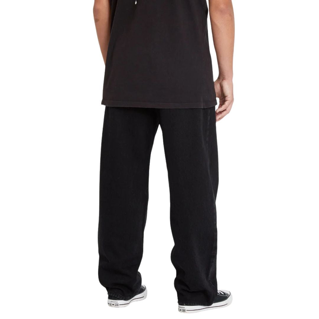 Vaquero Volcom Billow Denim color negro, vista trasera mostrando el corte holgado del pantalón, la costura central y la caída amplia característica del fit loose.