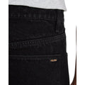 Primer plano del bolsillo trasero derecho del pantalón vaquero Volcom Billow Denim negro, con la etiqueta tejida Volcom cosida en la parte superior del bolsillo.