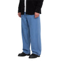 Pantalón vaquero Volcom Billow Denim en azul Cali Blue, vista lateral de cintura para abajo sobre modelo con camisa negra, mostrando la costura central y el ancho de la pernera.
