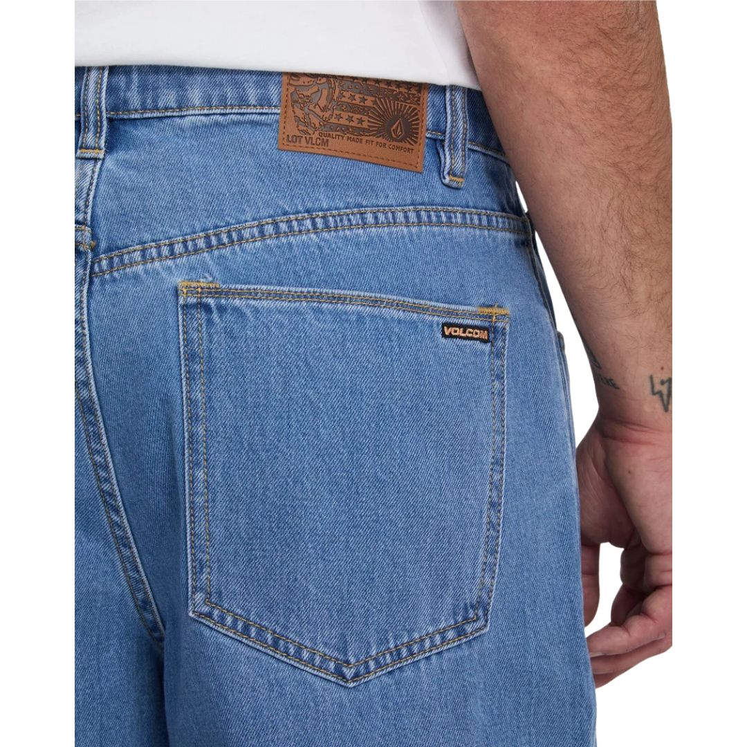 Detalle del bolsillo trasero del pantalón vaquero Volcom Billow Denim en azul Cali Blue, con la etiqueta de cuero de la marca y la etiqueta tejida Volcom cosidas en el bolsillo.