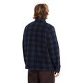 Vista trasera de hombre con sobrecamisa Volcom Bowered II en color azul marino a cuadros, mostrando el ajuste en la espalda y el corte boxy de la prenda.